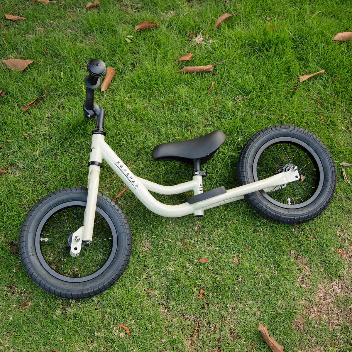 Køvapää krijtgrijze 2-in-1 loopfiets buiten in het gras gefotografeerd