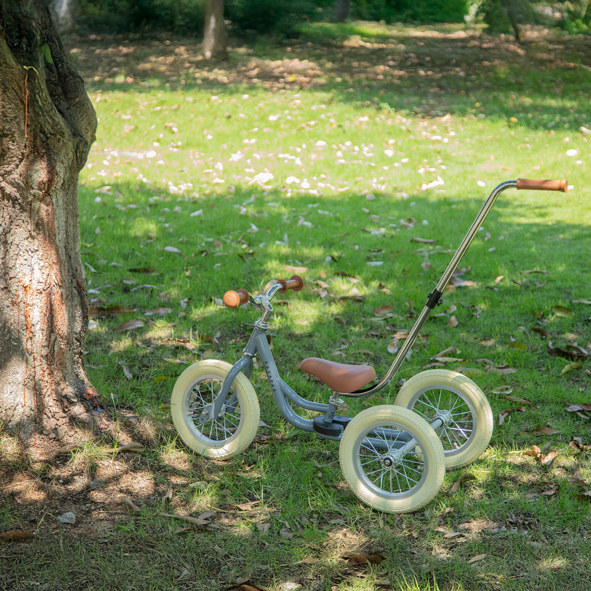 grijze Køvapää 2-in-1 loopfiets buiten in het gras gefotografeerd