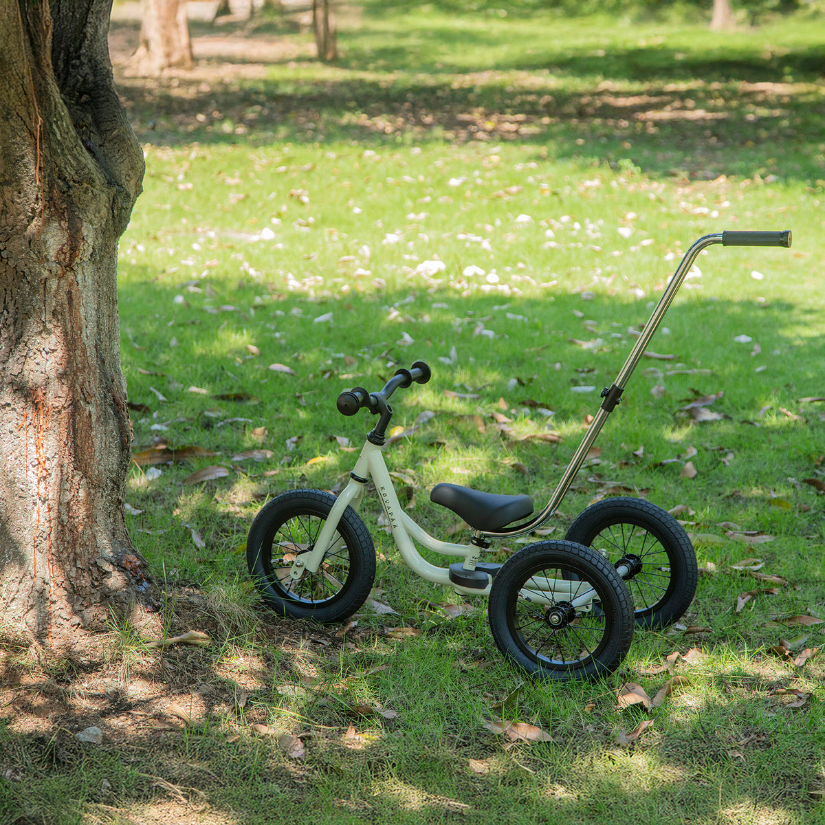 krijtgrijze Køvapää 2-in-1 loopfiets buiten in het gras gefotografeerd