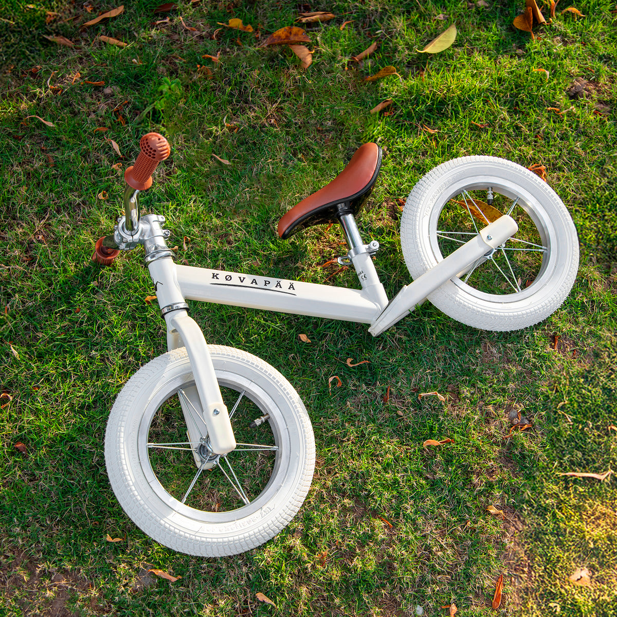 beige Køvapää loopfiets buiten in het gras gefotografeerd