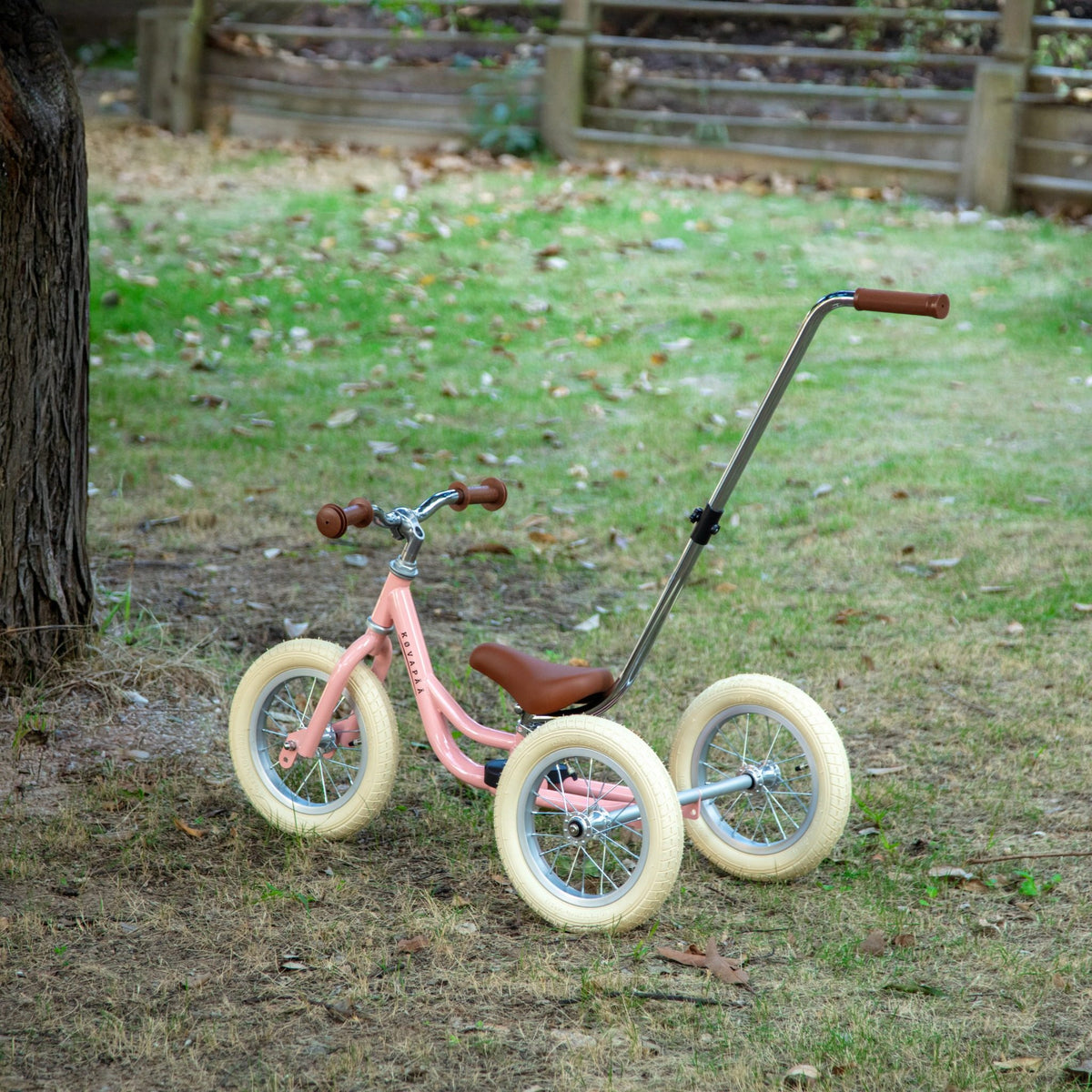 Roze Køvapää 2-in-1 loopfiets buiten in het gras gefotografeerd